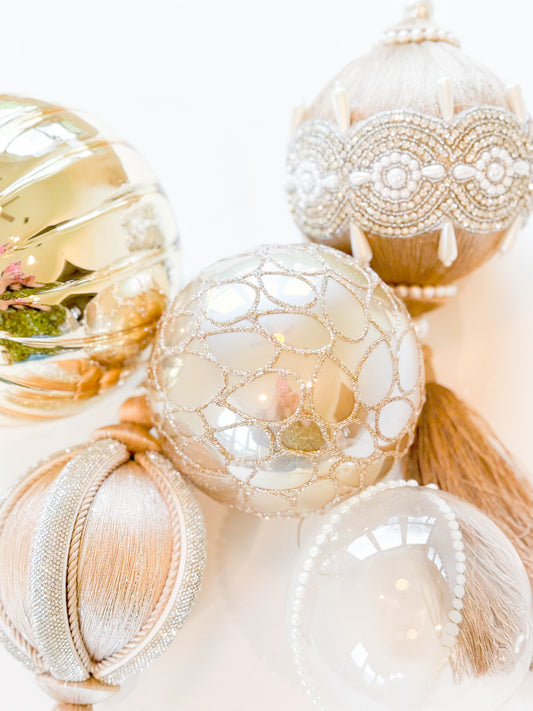 Elegant holiday ornaments with gold, silver, and pearl accents, featuring intricate beading and delicate textures.