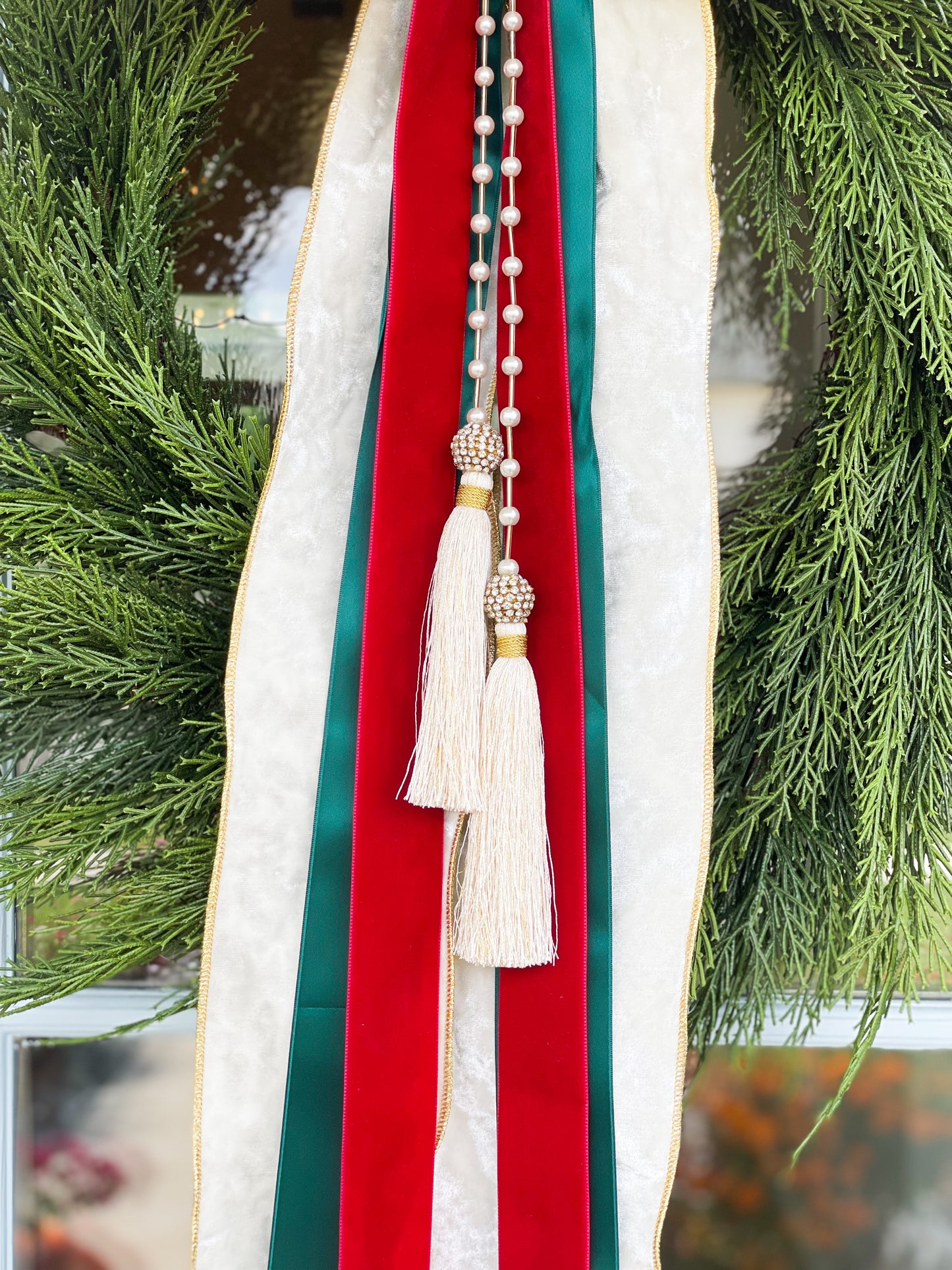 The White Noel Cedar Wreath And Bow With Pearl Tassel.