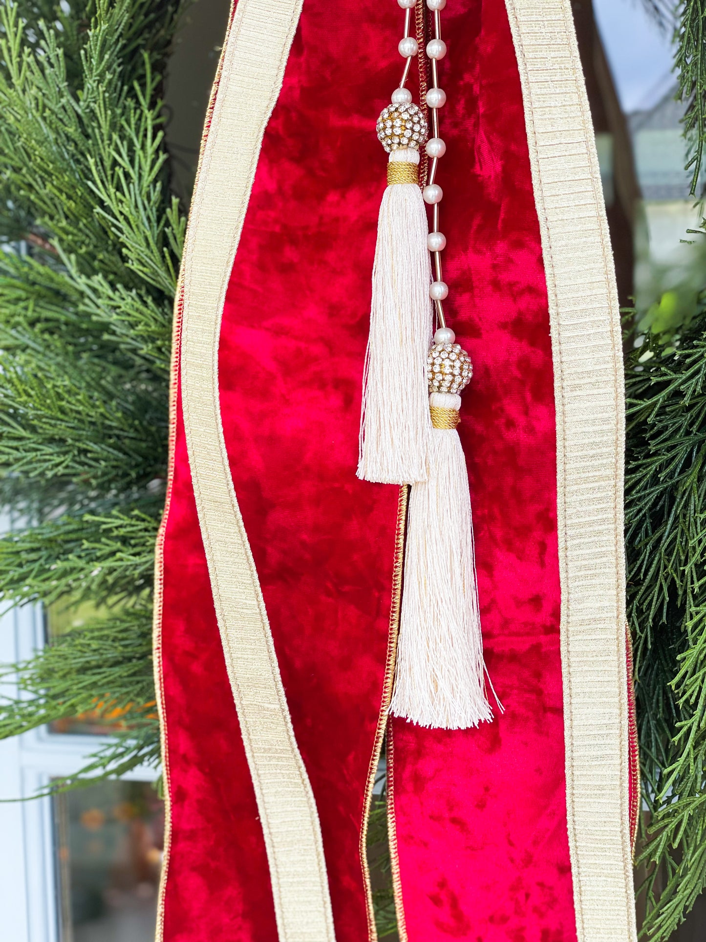 The Red Noel Cedar Wreath And Bow With Pearl Tassel.
